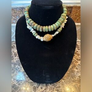 Elegant Green and pearl necklace with carved stone at the center.